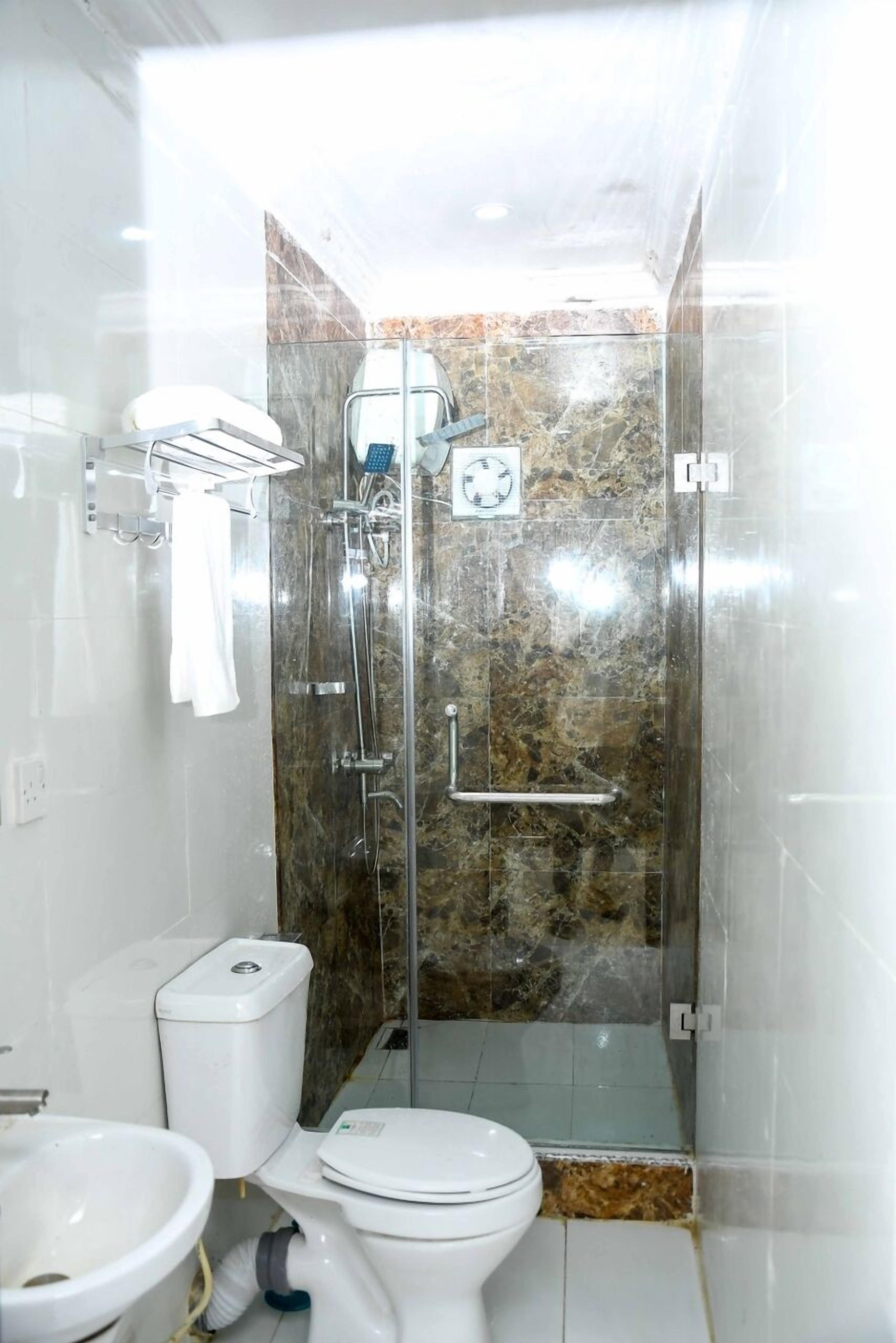Uma casa de banho moderna com chuveiro em cabine de vidro, sanita e lavatório.
