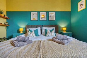 A bed with two pillows, a headboard, and two bedside tables with lamps.