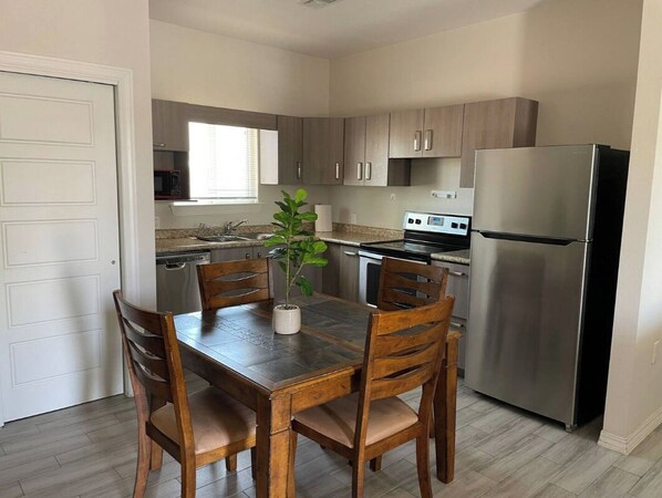 Enjoy meals in this compact kitchen with a dining table for four, equipped with a refrigerator and oven.