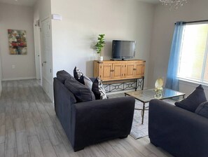 Relax in this stylish living room with a sofa, TV, and coffee table.