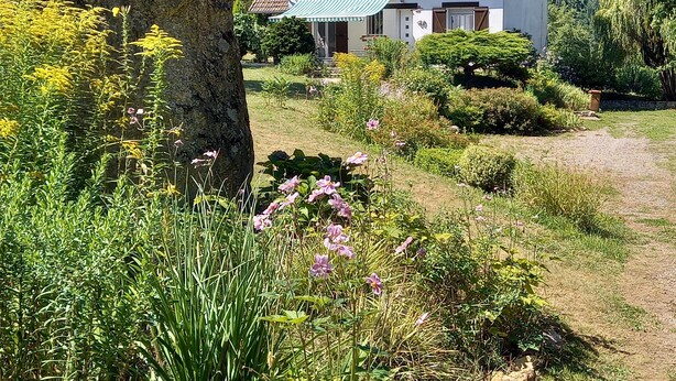 A white building with a red roof, surrounded by lush greenery and flowering plants. - Detached house in LE PARC DU MORVAN in Chalaux for 4 people. (Chalaux)