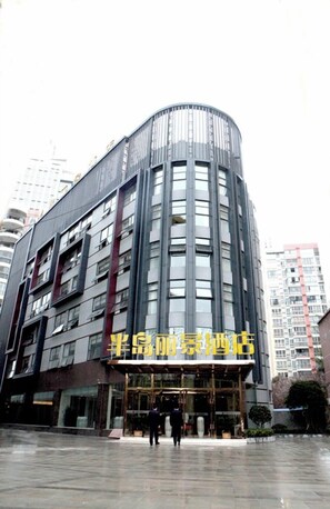 A modern building with a curved facade, large windows, and a prominent entrance. - Bandao Lijing Hotel (Lichuan)
