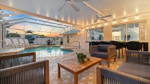 Un espace extérieur abrité comprenant une piscine, des chaises longues et un coin repas.