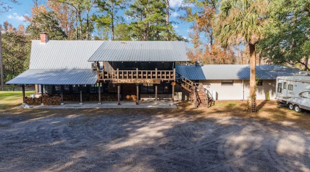 Un bâtiment à deux étages doté d’un porche couvert et d’une enseigne sur laquelle on peut lire « SEMINOLE SPRINGS ».