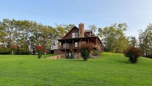 Una casa grande de dos pisos con cimientos de piedra y fachada de madera.