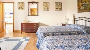 A bedroom with a bed, wooden dresser, and a mirror.
