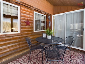 A wooden cabin with a round table and four chairs, a star decoration, and a sign prohibiting smoking inside. - Secluded Yet Close to Munising-Moose Tracks (Munising)