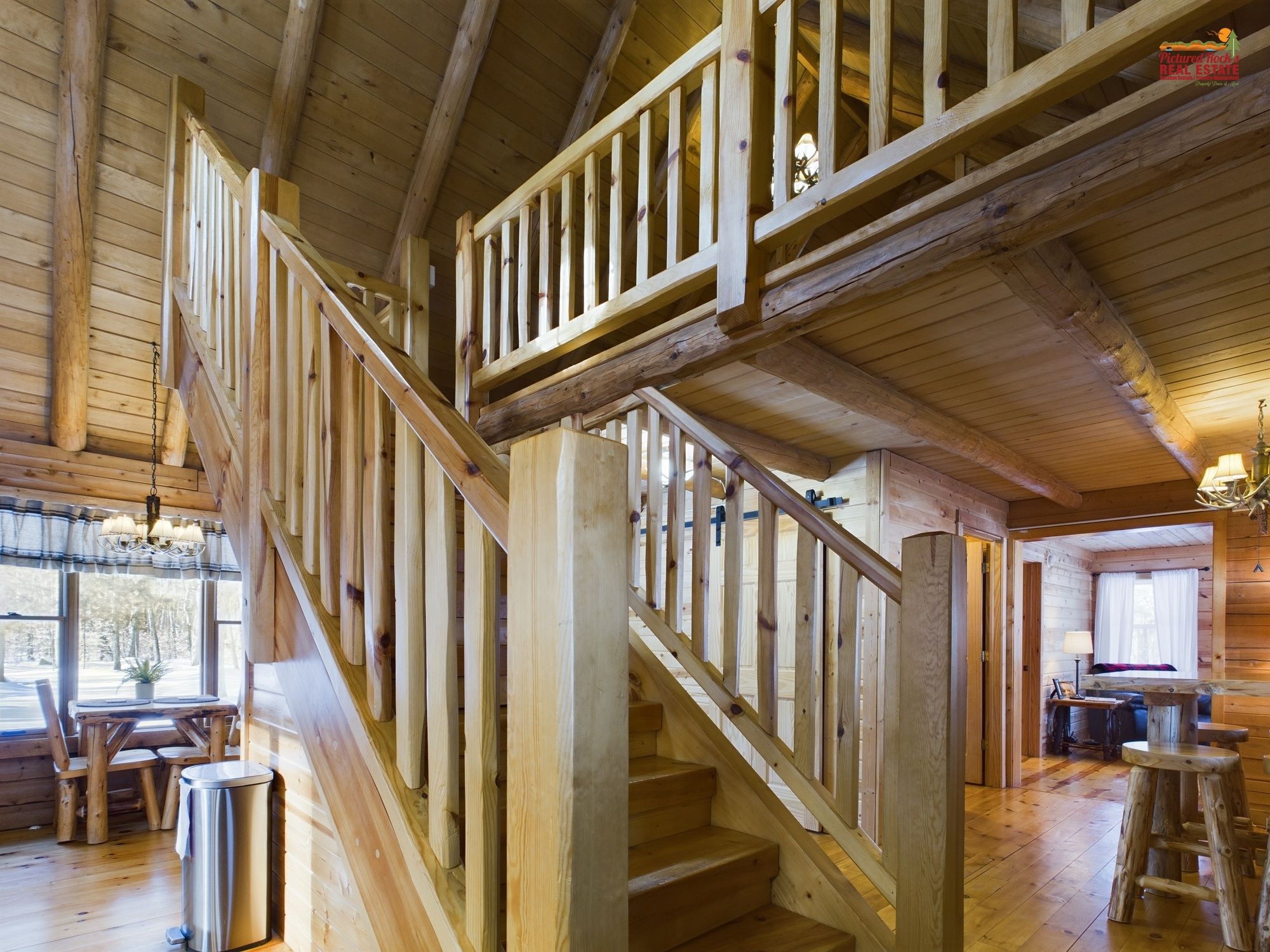 A wooden staircase with a railing, leading to an upper level.