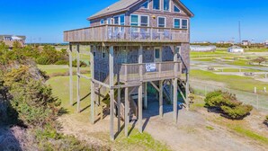 A wooden observation tower with a balcony, situated on a grassy area with a clear sky. - Semi-Oceanfront Dog Friendly Home w Newly Remodeled Kitchen, Grill, Beach Nearby (Waves)