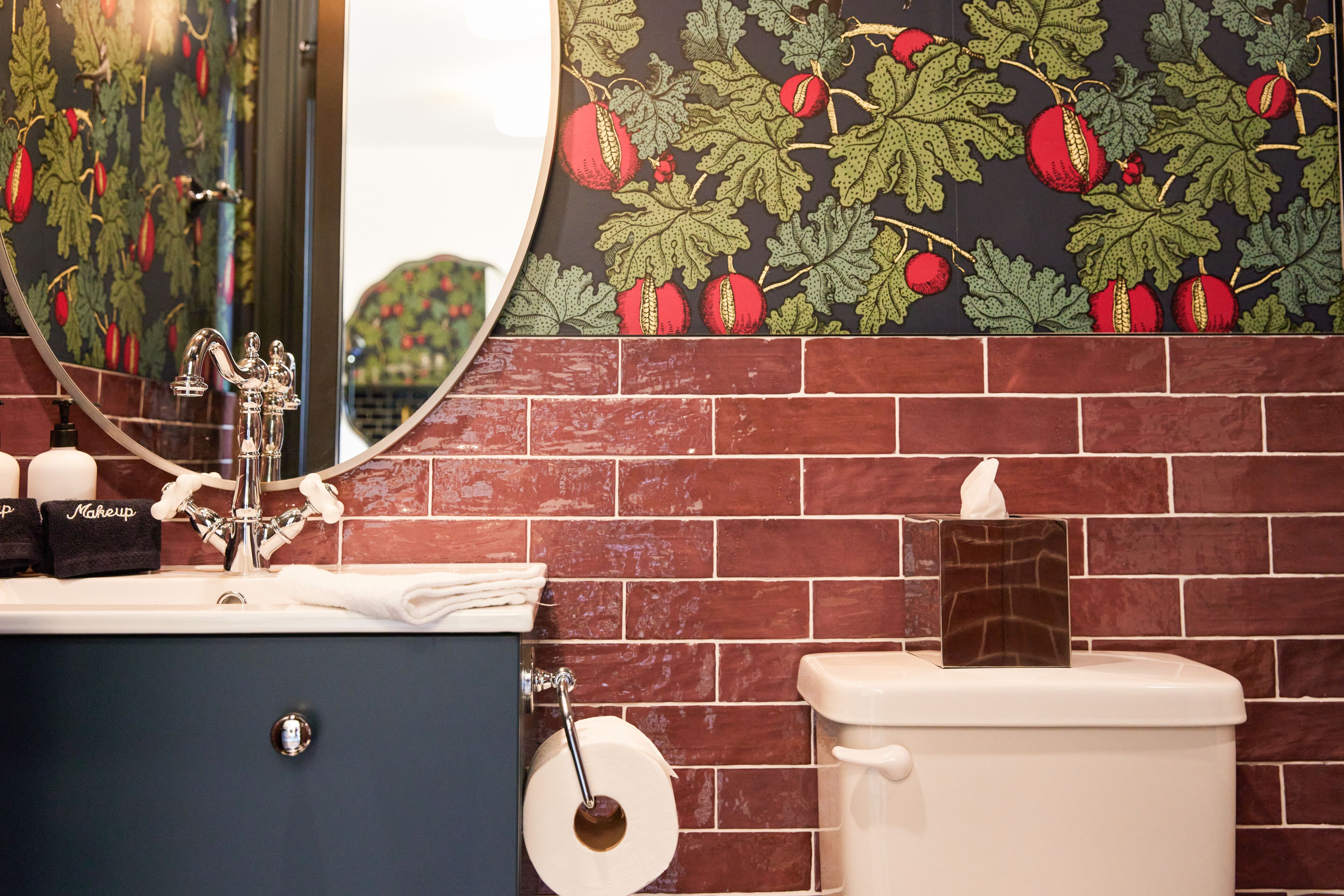 A bathroom with a mirror, sink, and toilet.
