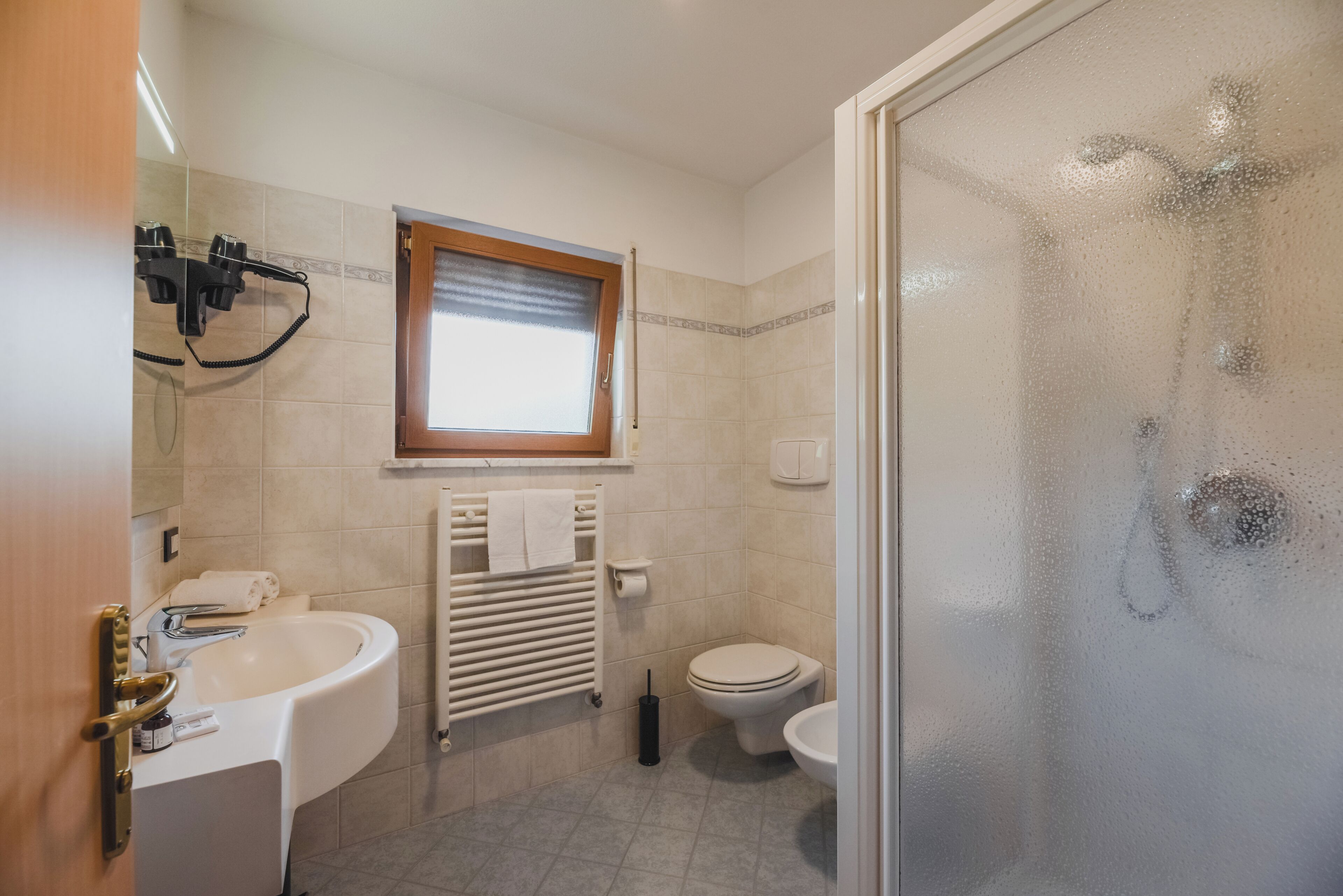 A bathroom with a bathtub, toilet, and a glass shower enclosure.