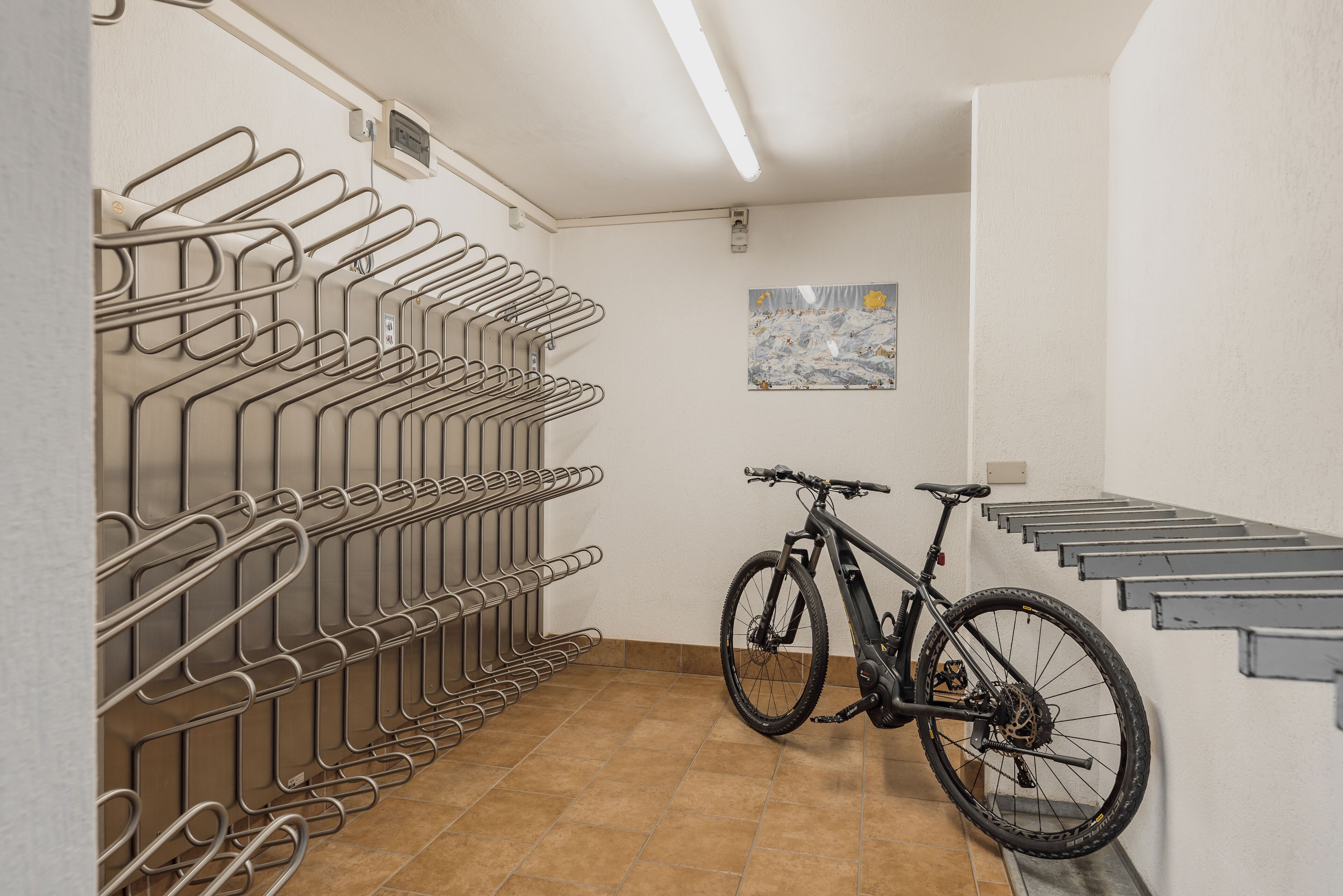 A bike storage area with multiple hooks and a bicycle parked.