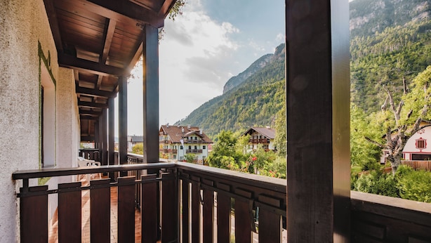 A balcony with a wooden railing overlooking a mountainous landscape.