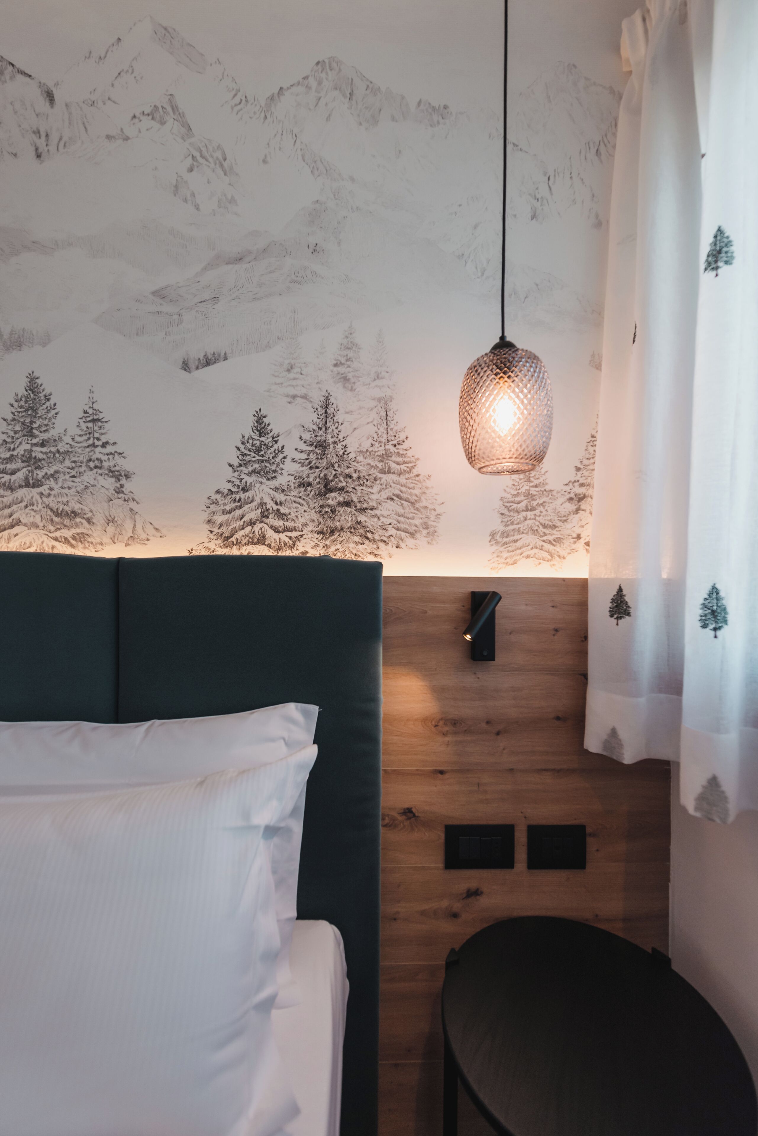 Ein Schlafzimmer mit einem Bett, einer Hängelampe, einer Holzpaneelausstattung und einem Vorhang mit Berggedeck.