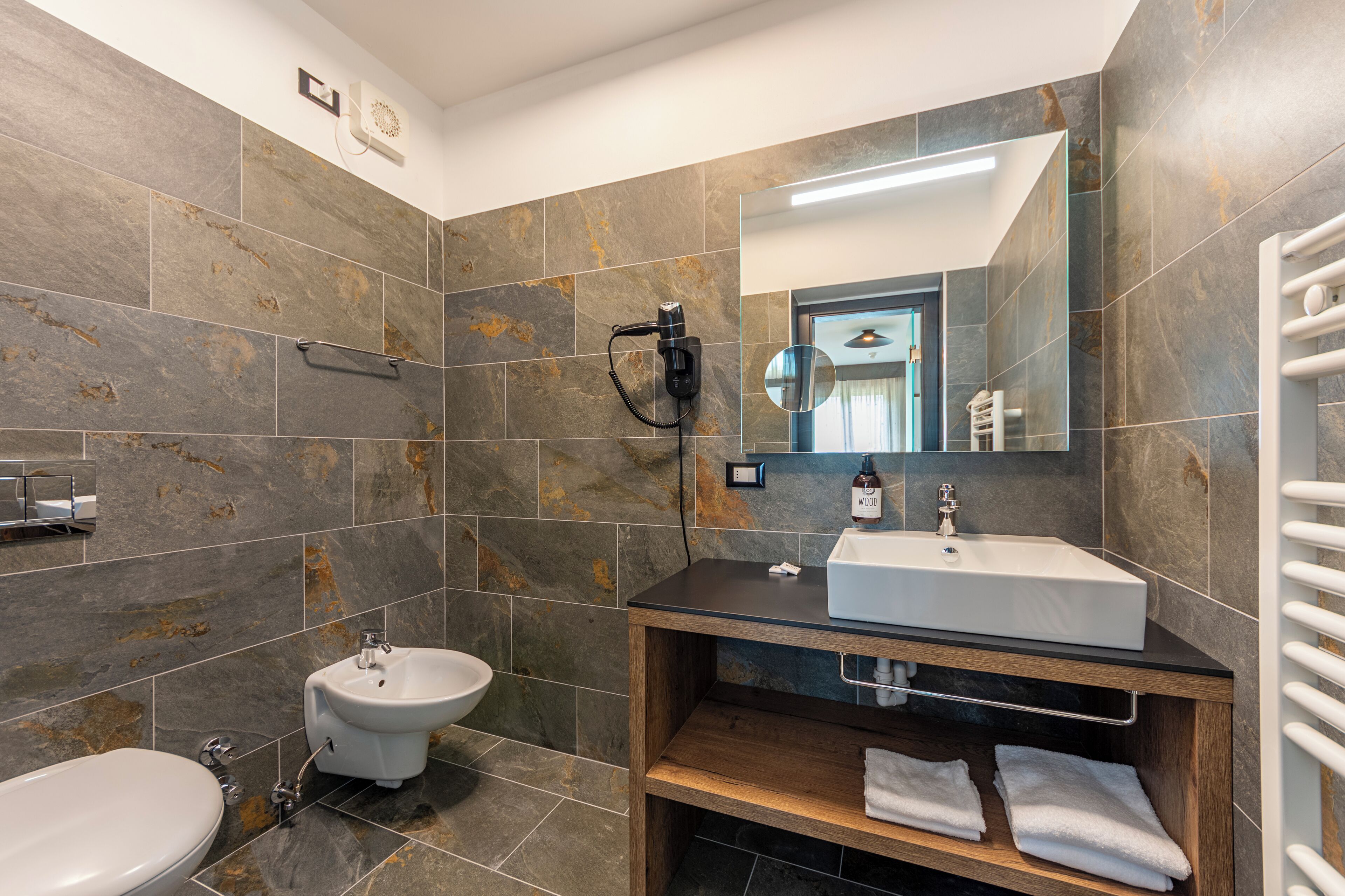 Een moderne badkamer met een bidet, een wastafel en een spiegel.