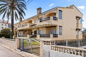 Stylish two-story home with a balcony and gated entrance.