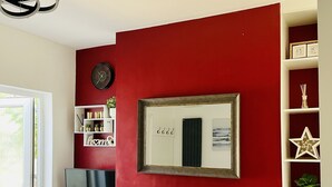 A living room with a red accent wall, a flat-screen TV, a fireplace, and a bookshelf. - 18 Horner Street York (York)