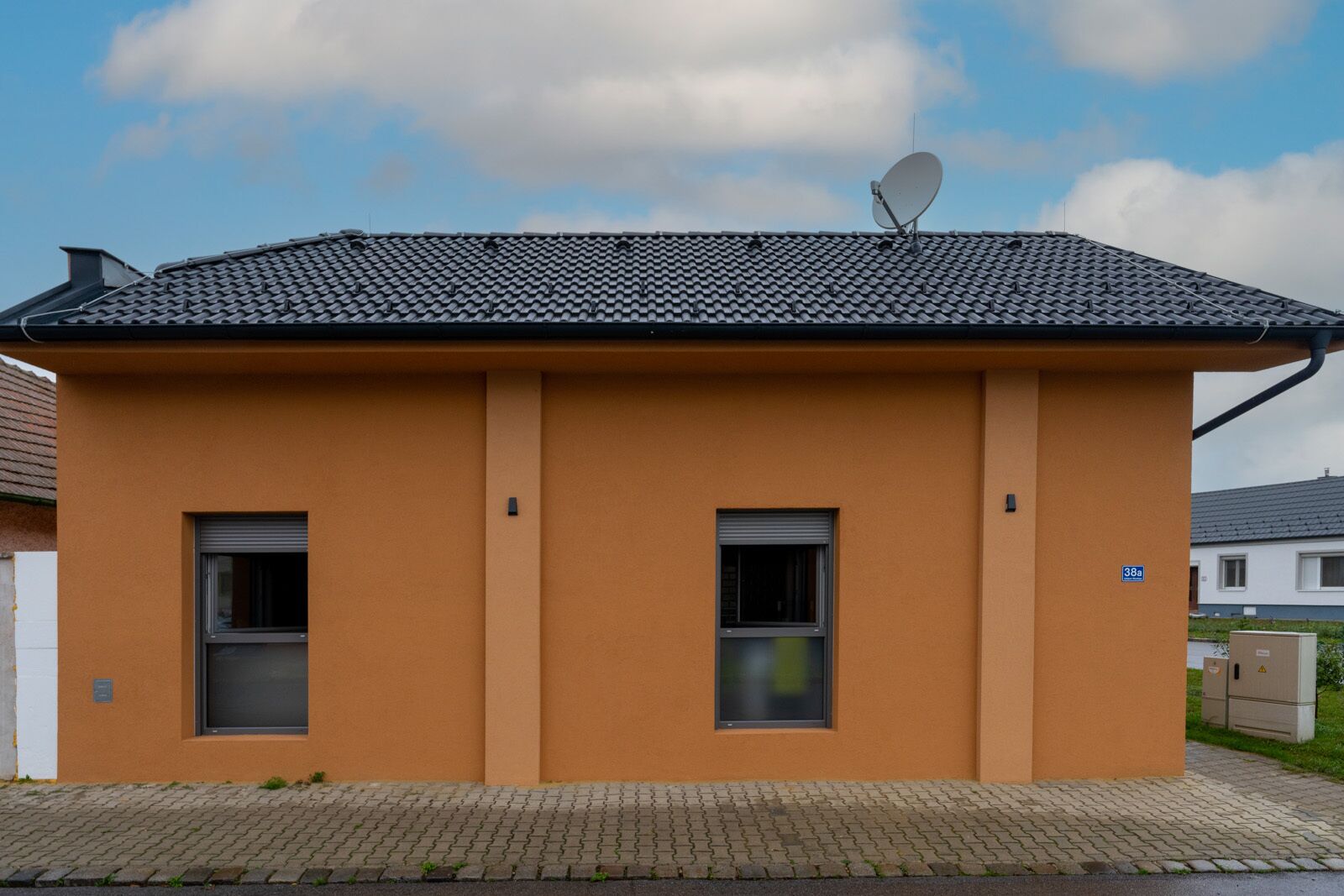 A small, single-story building with a tiled roof and two windows.
