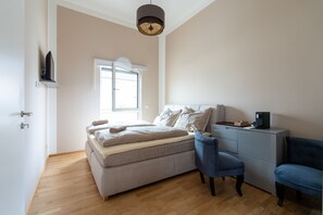A bedroom with a bed, two chairs, a desk, and a window. - Pension Pannonia (Parndorf)