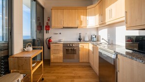 Een moderne keuken met houten kastjes, roestvrijstalen apparatuur en een granieten aanrecht.
