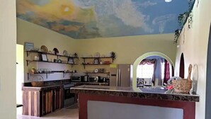 Une cuisine dotée d’un îlot central, d’appareils électroménagers intégrés et d’un plafond décoratif.