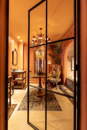 Relax in style with a comfortable armchair and sofa, surrounded by a mix of traditional and modern elements.