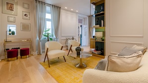 A modern living room with a sofa, armchairs, a coffee table, and a bookshelf. - BCascais Boutique House by APT IIN - Cascais Center (Cascais)