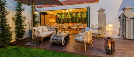 An outdoor patio with a sofa, chairs, a table, and a decorative lantern.