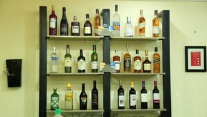 Una zona de bar con varias estanterías llenas de diferentes botellas de alcohol.