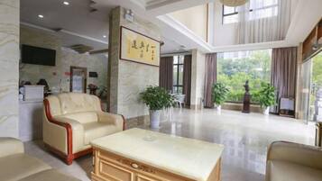 A spacious lobby with a marble reception desk, leather sofas, and a large coffee table.