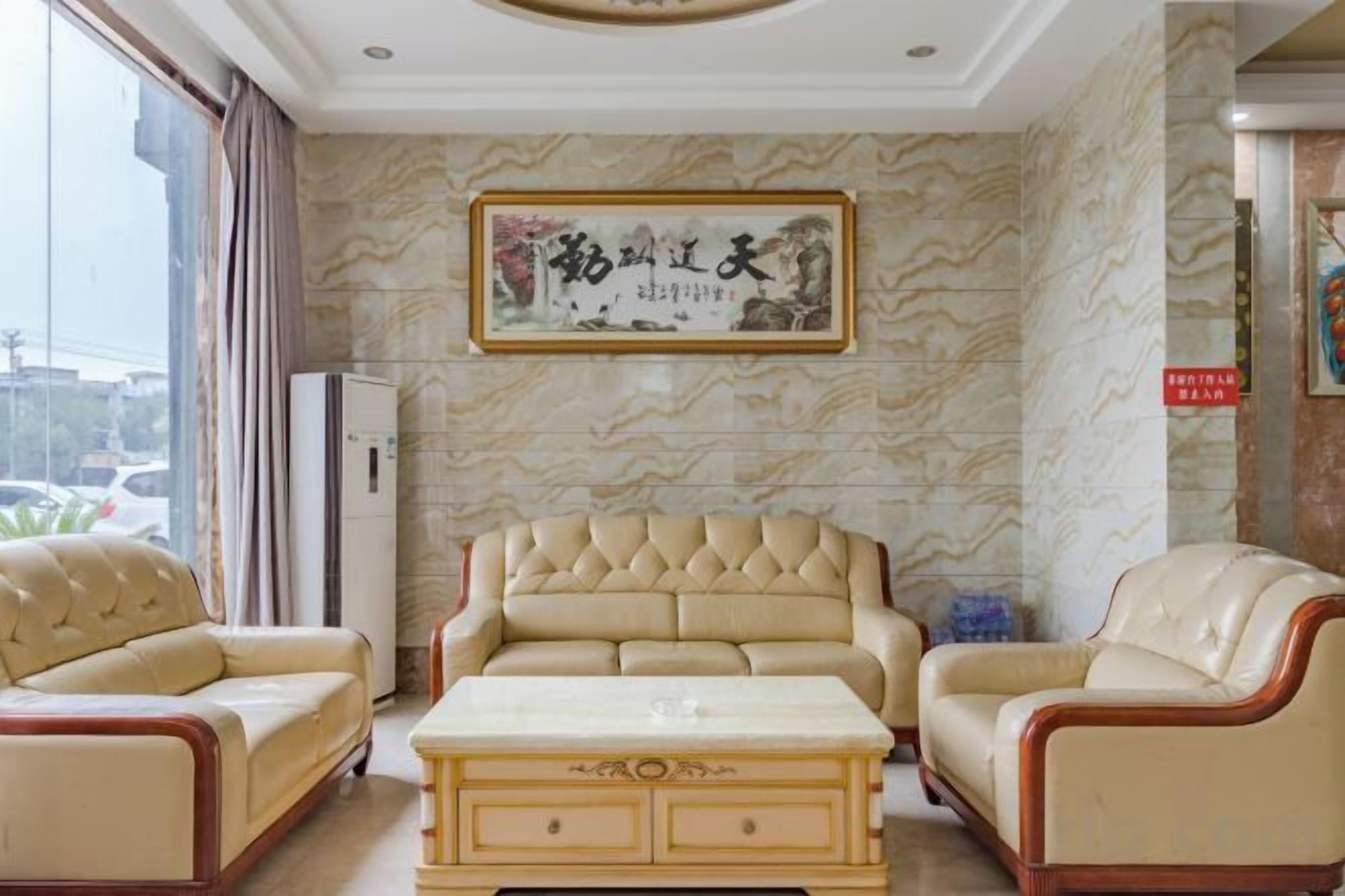 Una habitación con un conjunto de sofás, una mesa de centro y una pared decorada con una obra enmarcada.
