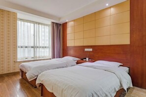 A hotel room with two beds, wooden flooring, a large window with curtains, and a wooden headboard. - Dijing Express Hotel (Qingyang)