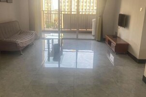 Una sala de estar con un sofá, una mesa de centro y un televisor en la pared.