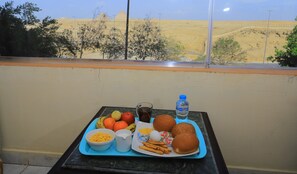 A balcony with a table set with food and a bottle of water. -  Pyramita Hotel (Giza)