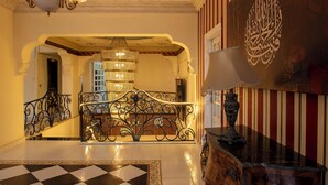 A grand lobby with a checkered floor, ornate metal railing, and a chandelier. -  Pyramita Hotel (Giza)