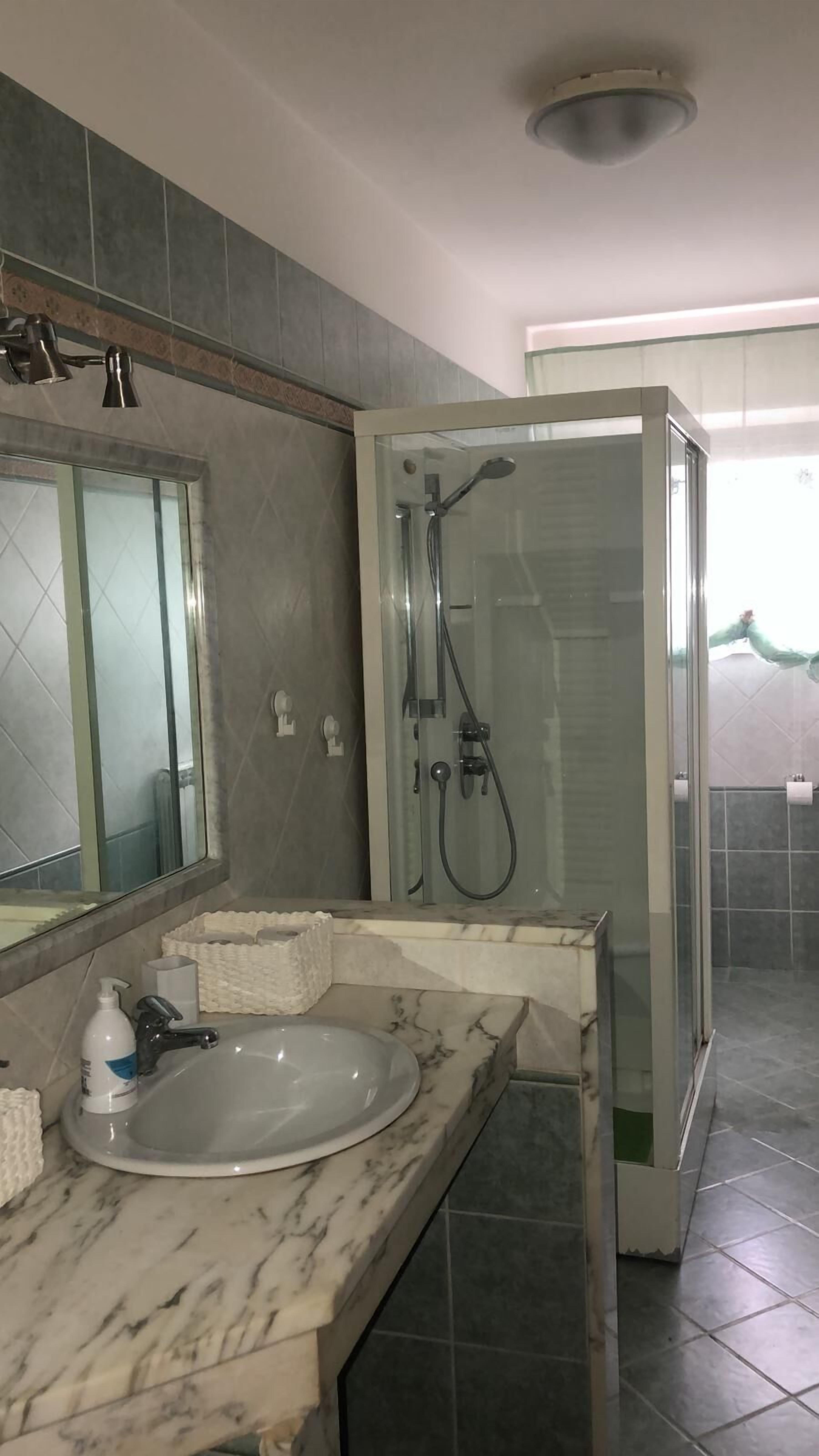 Een douche, een bidet, handdoeken, toiletpapier