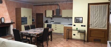 A compact kitchen with a dining area, a built-in oven, and a small refrigerator.