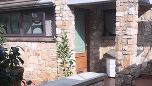 A stone building with a tiled patio, a basketball hoop, and a potted plant. - Cozy and independent apartment with garden! (Borgo A Buggiano)
