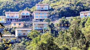 A hillside hotel with multiple buildings, each with balconies and a uniform architectural style. - Cliff Hotel (Luocheng)