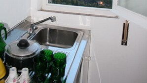Una cucina con una finestra, un lavello e vista su una zona boschiva.