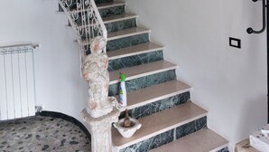 Una scala con ringhiera bianca e un quadro appeso sopra.