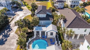 A residential area with a swimming pool surrounded by palm trees and houses. - When the Sun Goes Down 🌅 Navarre Retreat w/Golf Cart, Boat Slip + Pet Friendly (Navarre)