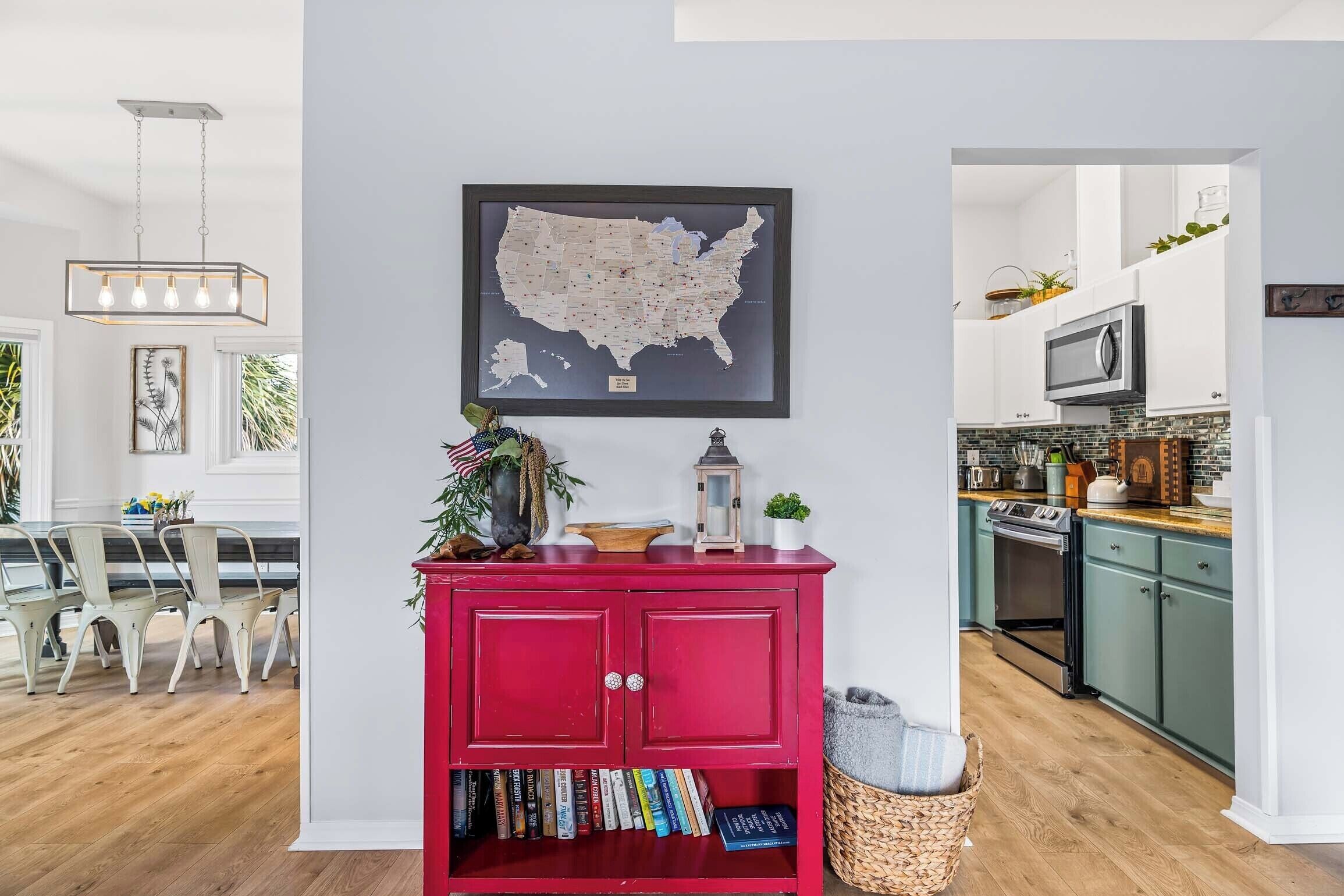 Une cuisine moderne avec des meubles de couleur turquoise, une bibliothèque rouge et une carte des États-Unis accrochée au mur.
