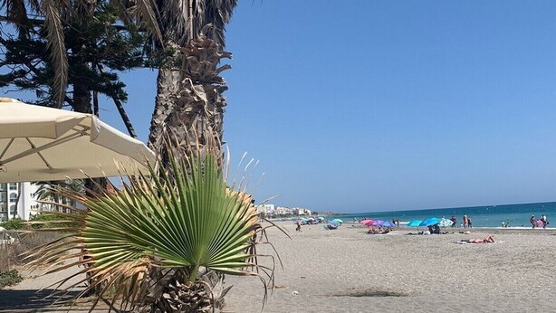 A beach with palm trees, beach umbrellas, and a clear blue sky. - Center, 2 min.de the beach, with terrace, air conditioning and heating. (Nerja)