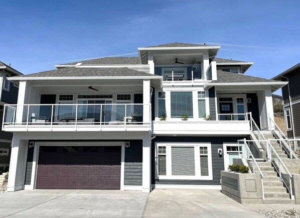 A modern two-story house with a garage, a balcony, and a staircase leading to the upper level.