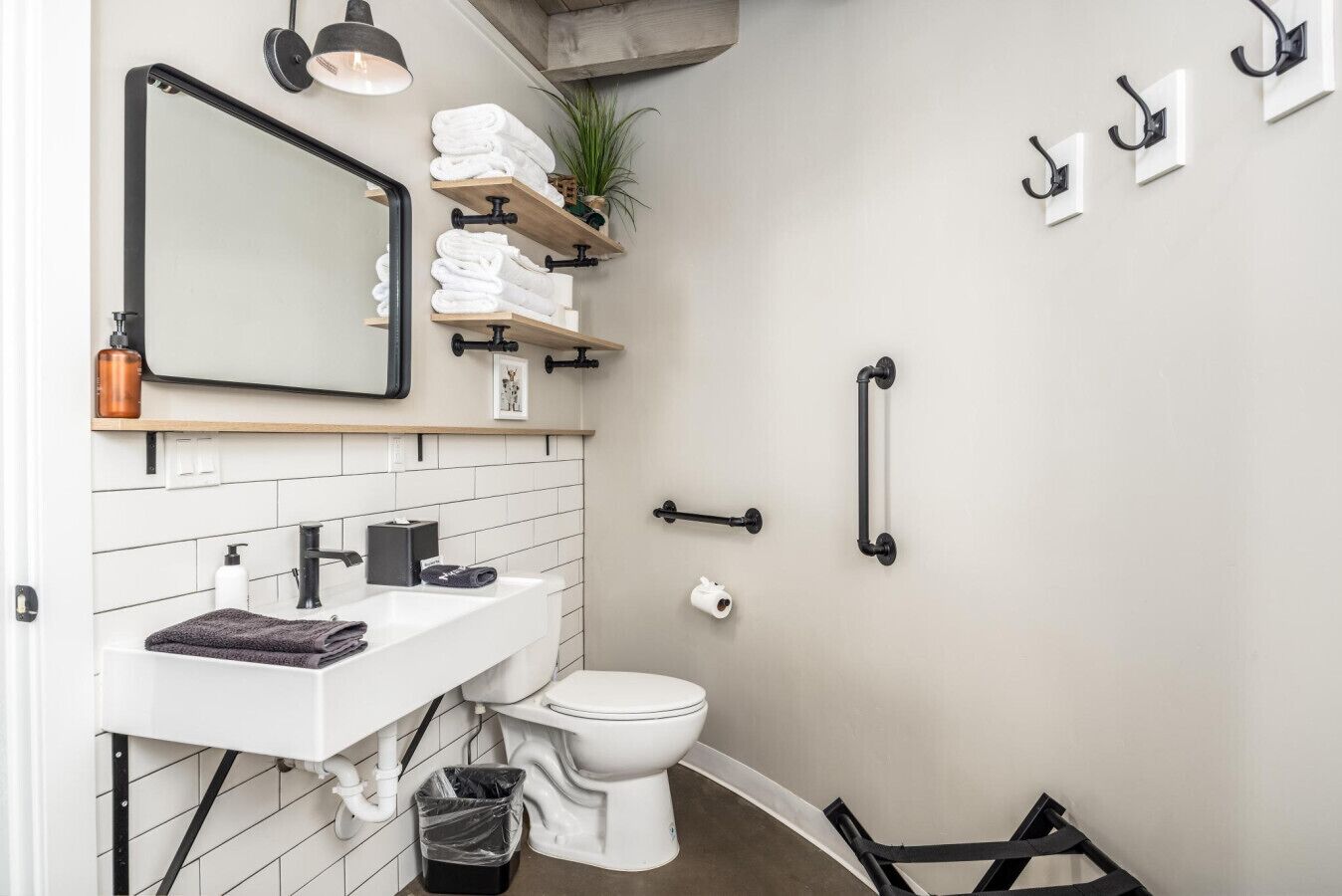 A bathroom with a white sink, a mirror, a toilet, and a towel rack.