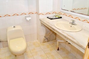 Un baño con inodoro, lavabo y espejo.