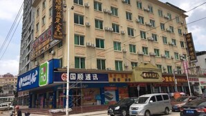 A multi-story building with various commercial establishments on the ground floor, including a bank and a convenience store. - Peigen Yizutang Hotel (Huizhou)