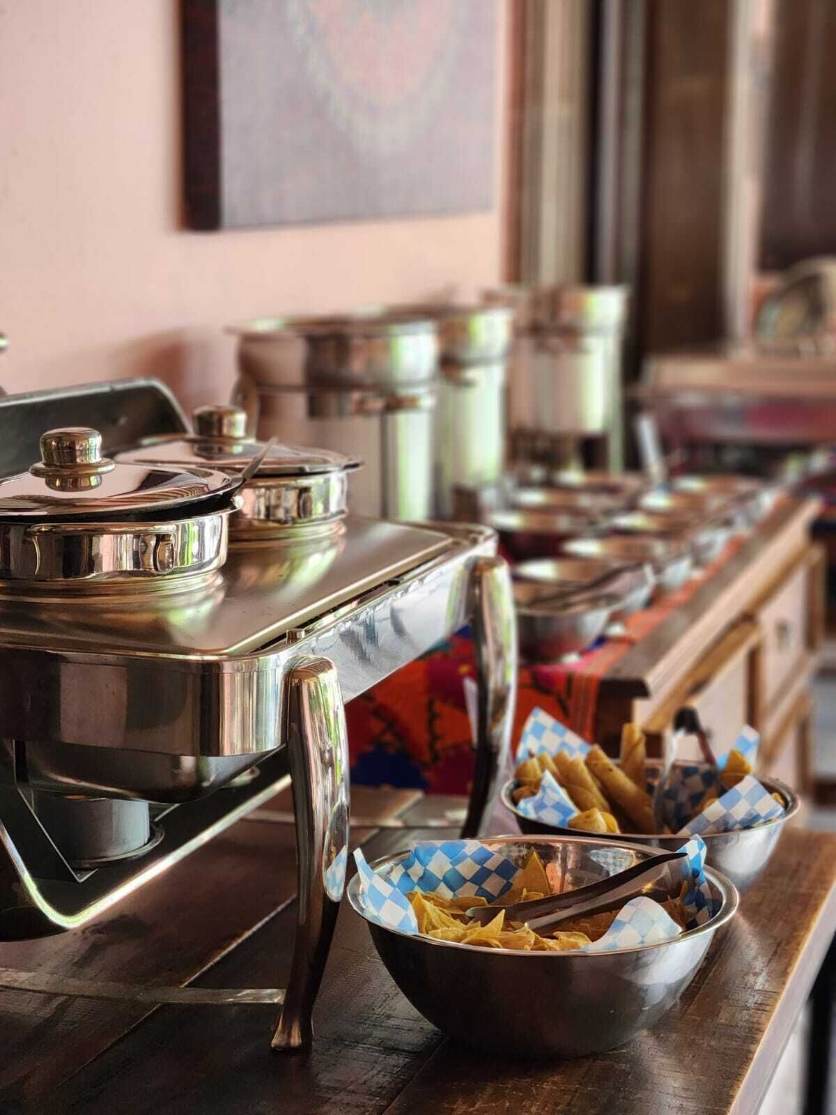 Un montaje tipo bufé con diferentes recipientes de comida y utensilios para servir.