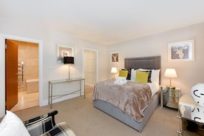 Cozy retreat with a large bed, bedside tables, and comfortable seating.